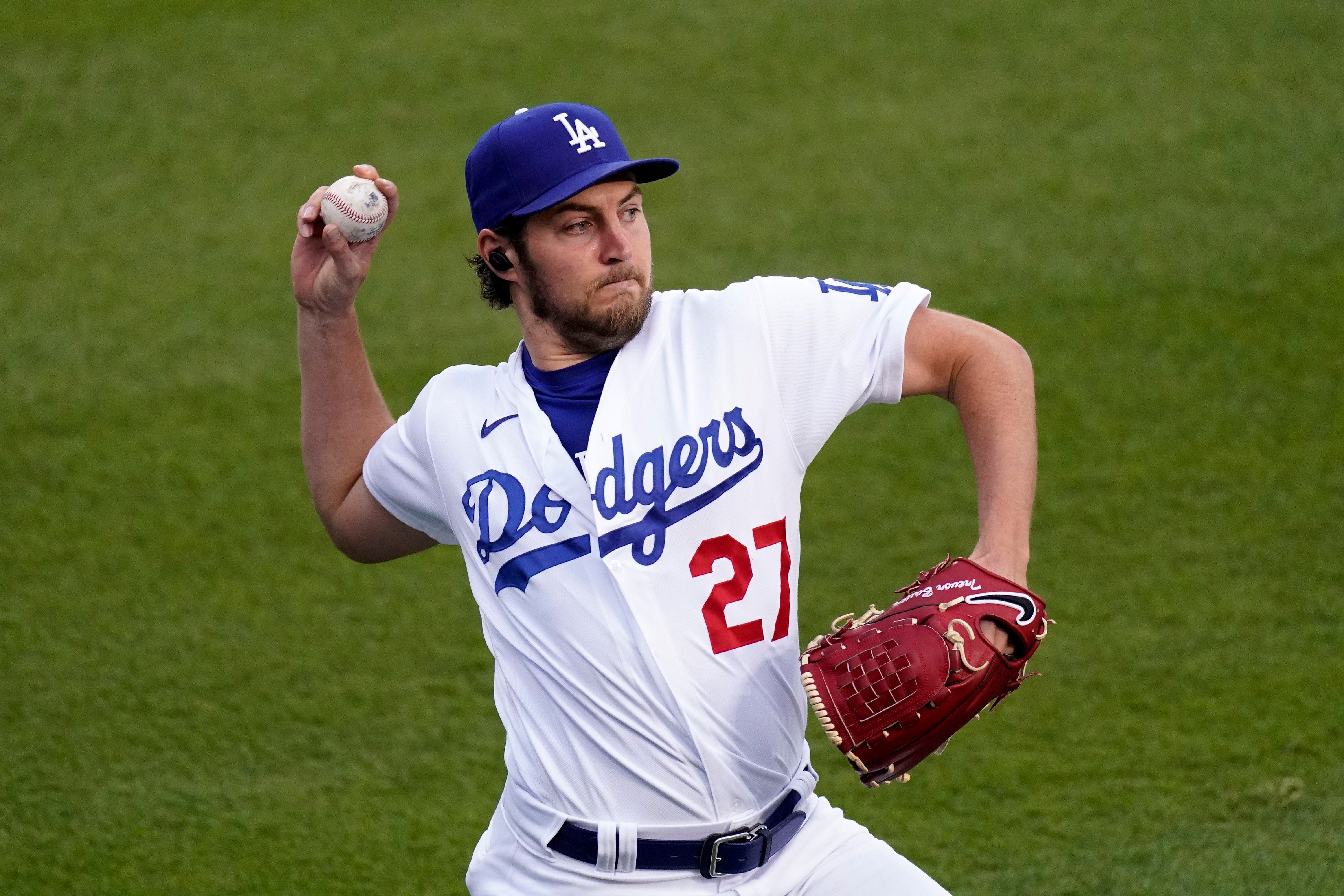 Trevor Bauer with his new uniform and cap of Yokohama DeNA BayStars poses  for photographers during a photo session of the news conference Friday,  March 24, 2023, in Yokohama, near Tokyo. (AP